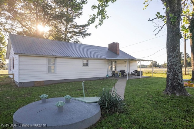 106595 S 4770th Rd, Muldrow, OK 74948 - rear view of property featuring a yard, a chimney, a metal roof, and a patio