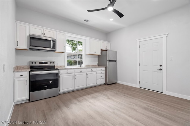 618 Sycamore St, Van Buren, AR 72956 - kitchen featuring stainless steel appliances, light wood finished floors, white cabinets, baseboards, and recessed lighting
