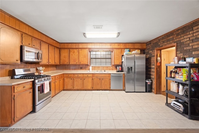 kitchen with sink, wooden walls, stainless steel appliances, and brick wall