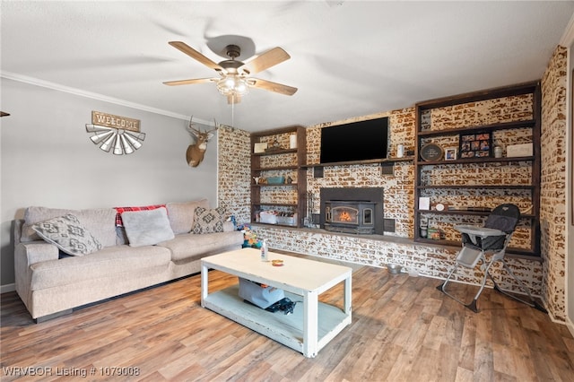 living room featuring wood-type flooring, ceiling fan, and crown molding