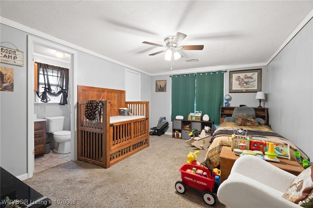 bedroom featuring crown molding, ensuite bath, ceiling fan, a textured ceiling, and light colored carpet