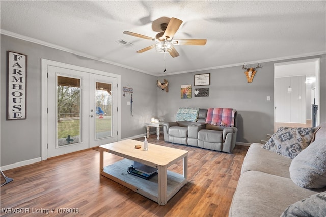 living room with french doors, crown molding, hardwood / wood-style floors, and a textured ceiling