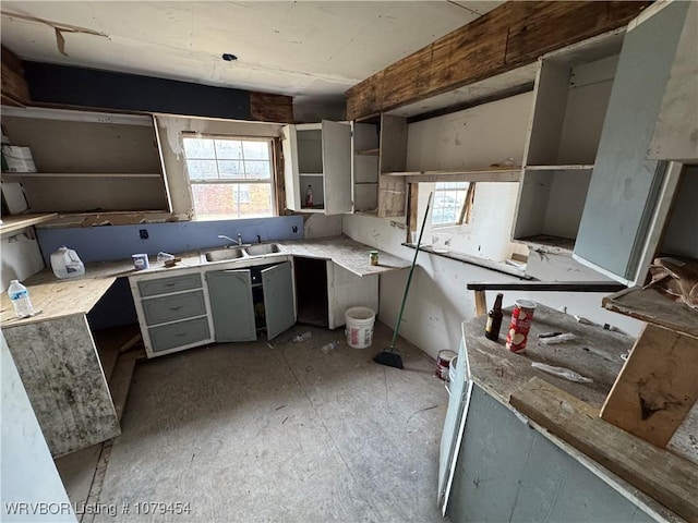 kitchen with a sink, a healthy amount of sunlight, gray cabinetry, and open shelves