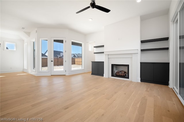 unfurnished living room with light wood-type flooring and ceiling fan