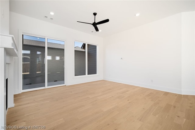 spare room with ceiling fan and light wood-type flooring