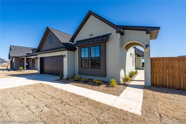 7631 Woodbine Ln, Fort Smith, AR 72916 - view of front of house featuring brick siding, a garage, driveway, and roof with shingles