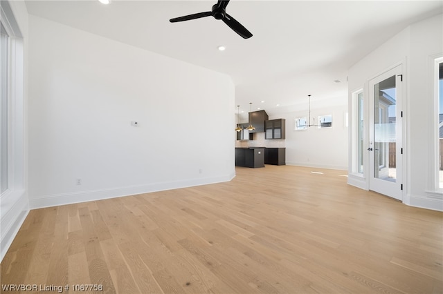 unfurnished living room with light hardwood / wood-style flooring and ceiling fan