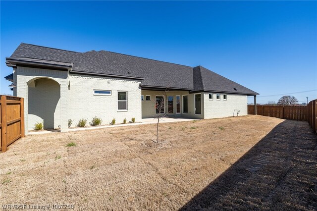 7631 Woodbine Ln, Fort Smith, AR 72916 - rear view of house with brick siding, roof with shingles, and a fenced backyard