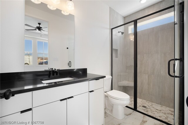 bathroom with ceiling fan, vanity, an enclosed shower, and toilet