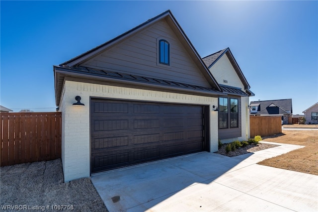 7631 Woodbine Ln, Fort Smith, AR 72916 - view of front of house with driveway, brick siding, a standing seam roof, a metal roof, and an attached garage