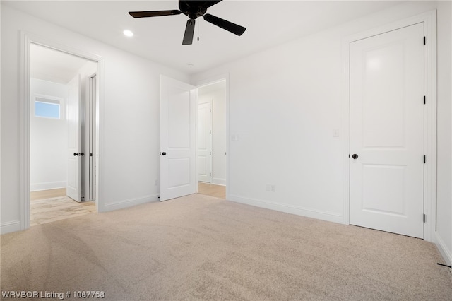 unfurnished bedroom with ceiling fan and light colored carpet