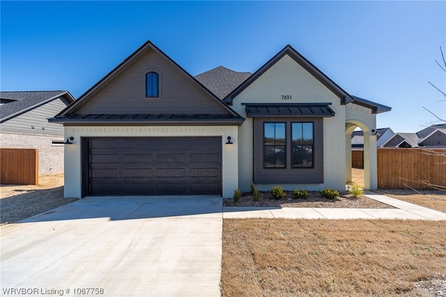 7631 Woodbine Ln, Fort Smith, AR 72916 - view of front of home with a standing seam roof, driveway, brick siding, a metal roof, and an attached garage