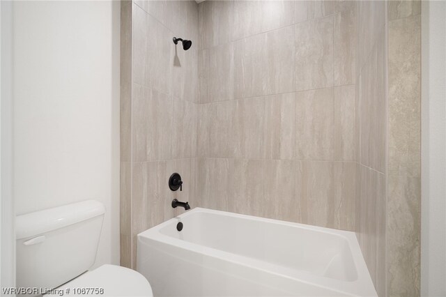 bathroom with tiled shower / bath combo and toilet