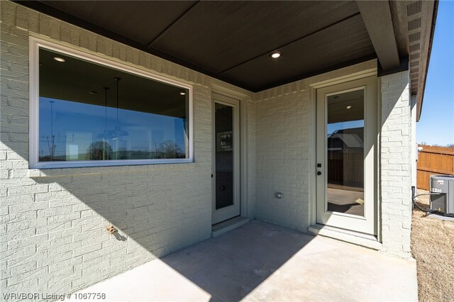 doorway to property with central air condition unit and a patio