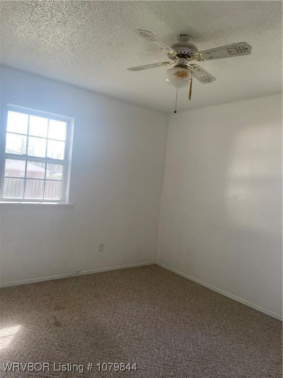 606 Highland Dr, Charleston, AR 72933 - carpeted empty room with baseboards, a textured ceiling, and ceiling fan