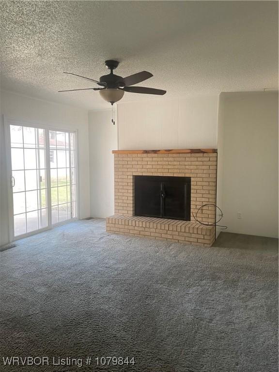 606 Highland Dr, Charleston, AR 72933 - unfurnished living room with a ceiling fan, a brick fireplace, carpet, and a textured ceiling