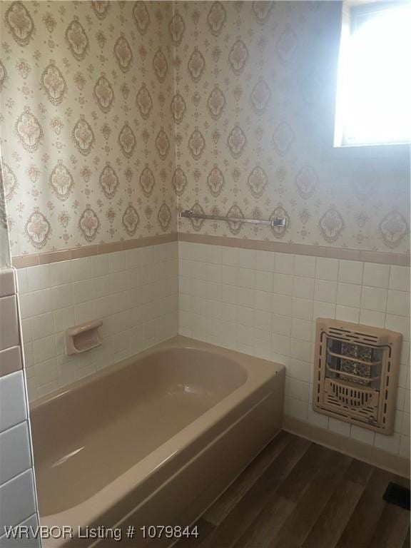 606 Highland Dr, Charleston, AR 72933 - bathroom featuring wainscoting, a garden tub, wood finished floors, and wallpapered walls