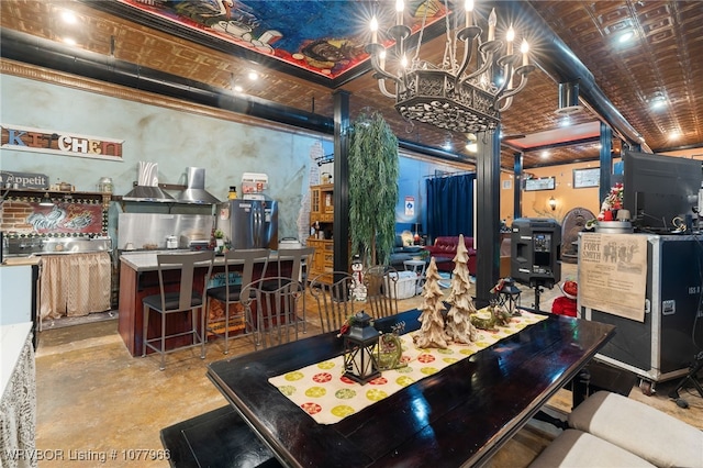 kitchen featuring a breakfast bar, a center island, an inviting chandelier, and stainless steel refrigerator