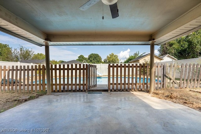 view of patio with a fenced in pool and ceiling fan