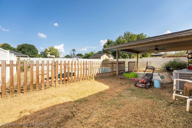 view of yard with central AC unit and ceiling fan