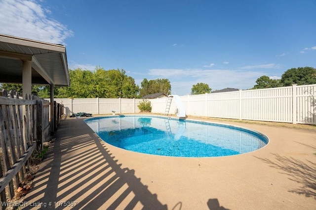 view of pool with a patio area and a water slide