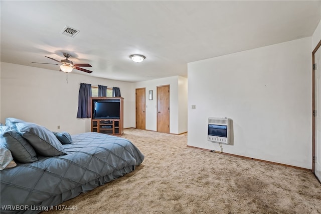 carpeted bedroom with heating unit and ceiling fan