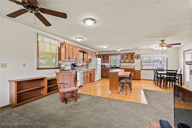 kitchen with light carpet, stainless steel dishwasher, ceiling fan, sink, and white fridge