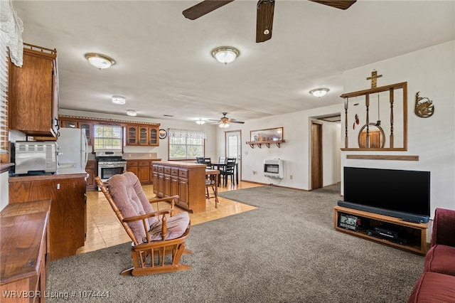 living room with a stone fireplace, light carpet, and heating unit