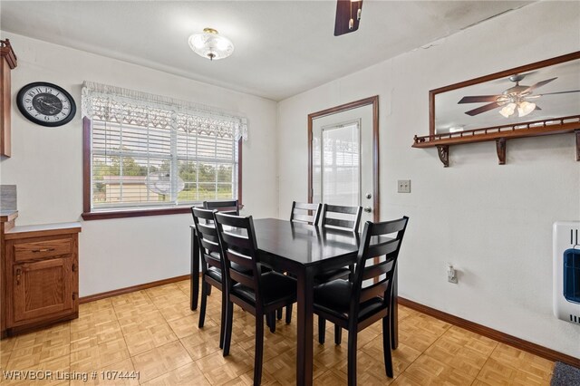 dining area with heating unit, ceiling fan, and light parquet floors