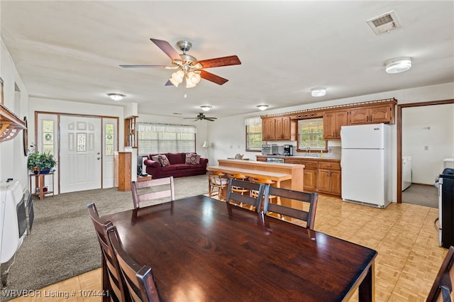 dining room with light carpet, plenty of natural light, and ceiling fan