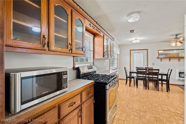 kitchen featuring ceiling fan, appliances with stainless steel finishes, and heating unit