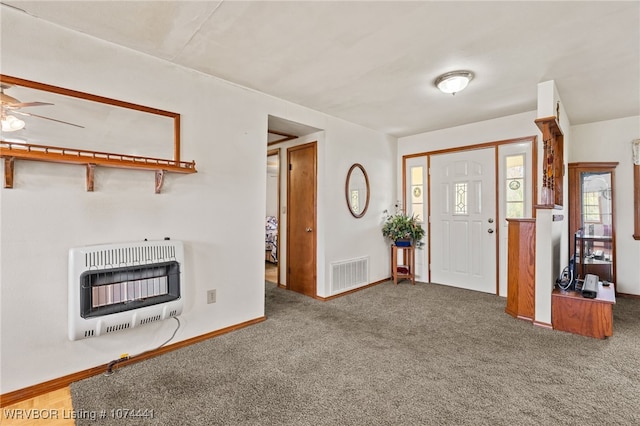 carpeted entryway with heating unit and ceiling fan