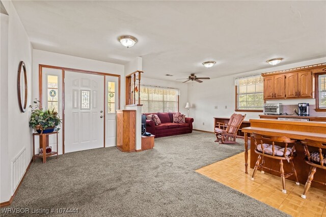 interior space featuring ceiling fan and light carpet