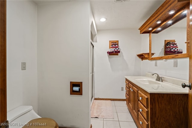 bathroom with tile patterned flooring, vanity, toilet, and a shower with door