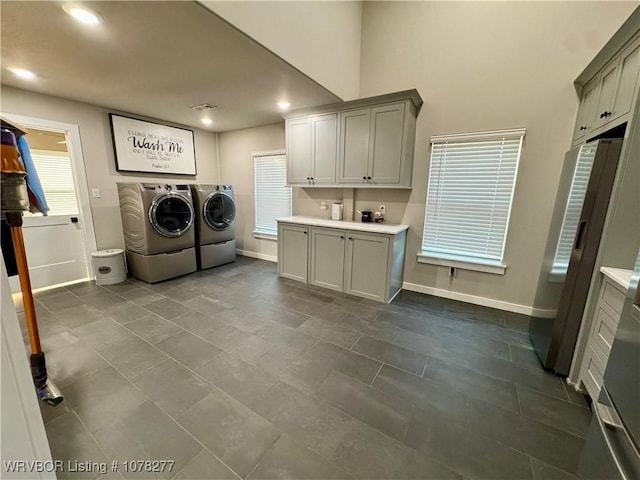 laundry room featuring separate washer and dryer and cabinets