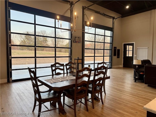 dining space with hardwood / wood-style floors and a towering ceiling