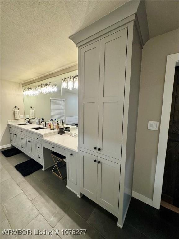 bathroom with tile patterned flooring, a textured ceiling, and vanity