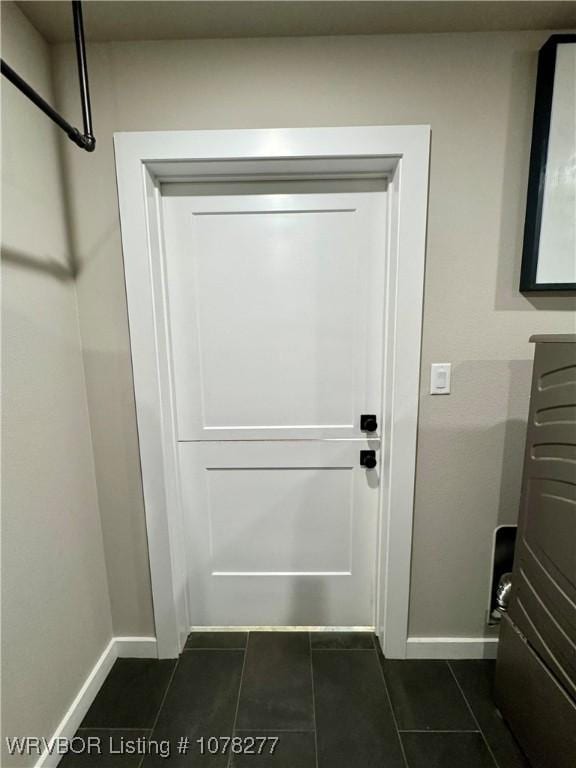 doorway with dark tile patterned floors