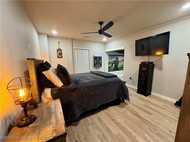 bedroom featuring ceiling fan, light wood-type flooring, and crown molding