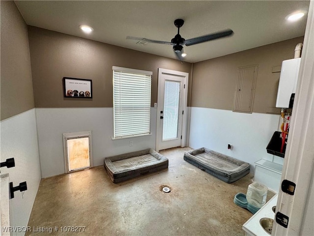 interior space featuring a wealth of natural light, ceiling fan, and concrete flooring