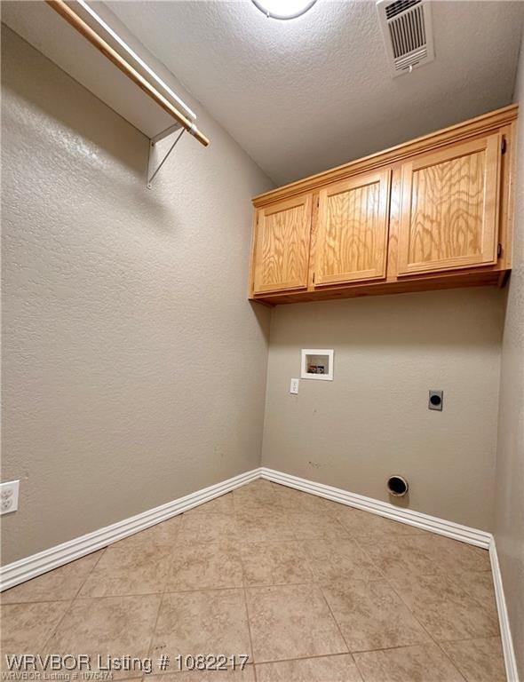 106 E Dora Ln, Poteau, OK 74953 - laundry room featuring hookup for a washing machine, cabinet space, a textured ceiling, electric dryer hookup, and light tile patterned floors