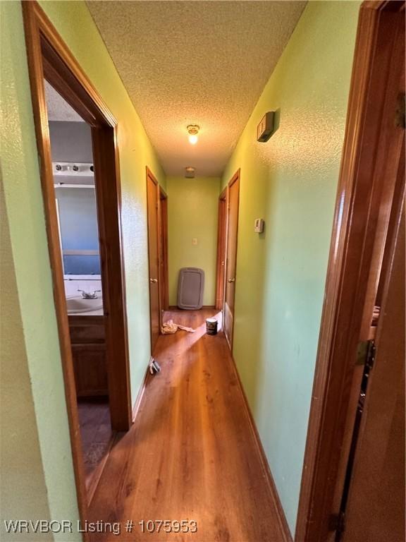 hall featuring hardwood / wood-style floors and a textured ceiling