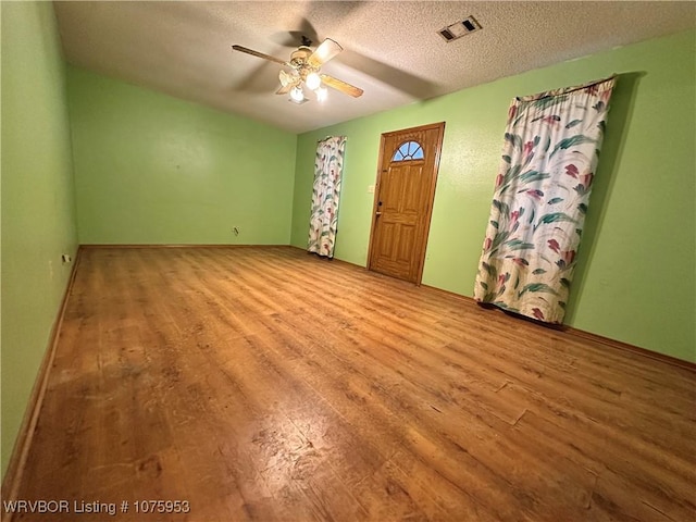 interior space with ceiling fan, a textured ceiling, and light hardwood / wood-style floors