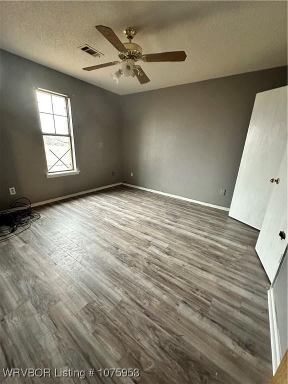 spare room with ceiling fan, hardwood / wood-style floors, and a textured ceiling