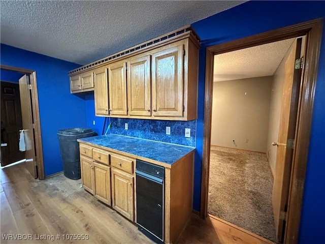 kitchen with light brown cabinetry, hardwood / wood-style floors, tasteful backsplash, and a textured ceiling