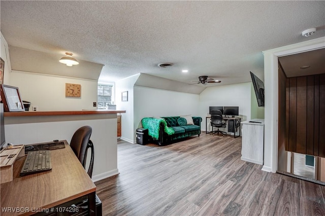 office area with hardwood / wood-style floors, ceiling fan, a textured ceiling, and vaulted ceiling