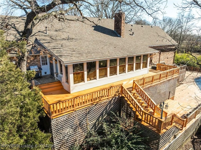 back of house featuring a sunroom and a wooden deck