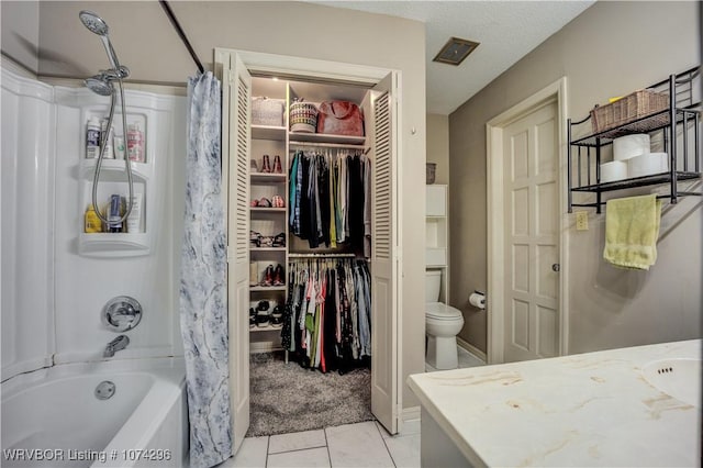 full bathroom with vanity, shower / bath combo, tile patterned floors, toilet, and a textured ceiling