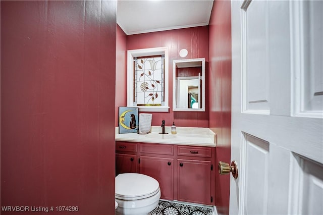 bathroom with crown molding, vanity, and toilet