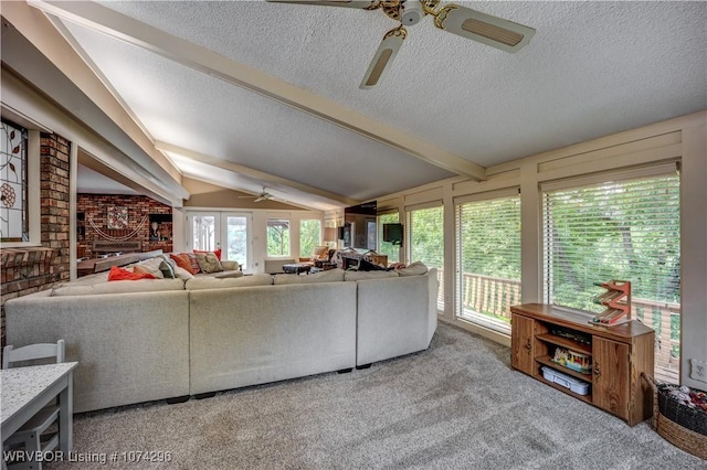 carpeted living room with vaulted ceiling with beams, ceiling fan, a fireplace, and a textured ceiling